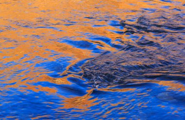 Sonbahar renkleri ve mavi gökyüzü dağlardaki küçük bir nehre yansıyor. Nevache, Fransa.