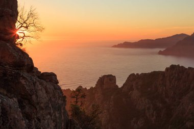 Günbatımında Fransa 'nın Korsika adasında Calanche ve Porto Körfezi uçurumları.
