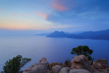 Porto Gölü 'nün üzerinde gün batımı ünlü Şato Kalesi yakınlarındaki kayalıklardan görüldü. Korsika, Fransa.