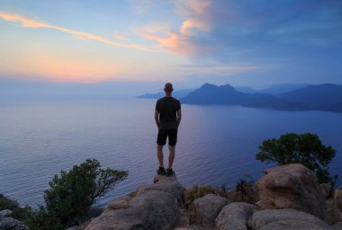 Ünlü Chateau Fort yakınlarındaki kayalıklardan Porto Golf 'üne bakan bir adam. Korsika, Fransa.
