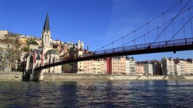 İnsanlar Fransa 'nın Lyon kentindeki Rhone nehri üzerindeki Passerelle Saint-Georges köprüsünde yürüyorlar..