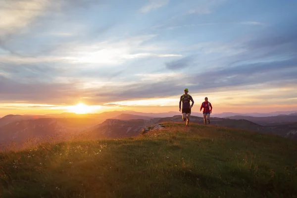 Gün batımında Massif du Vercors 'da koşan sporcular. Sığ D.O.F. Ve hareket bulanıklığıyla.