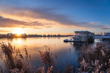 Rıhtımdaki modern mahallede renkli, kış gündoğumu. Meerstad, Hollanda.