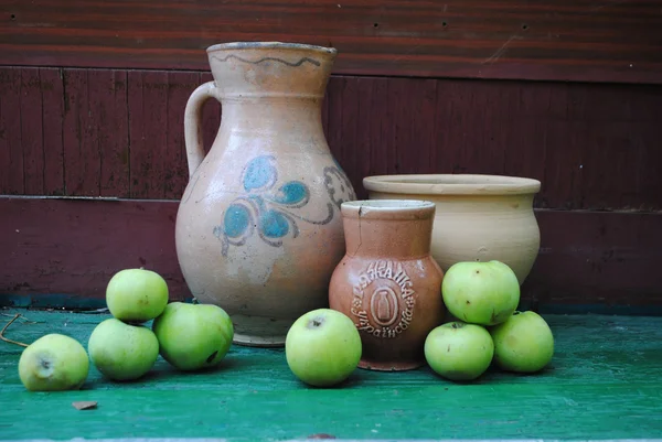 Старые вазы, миска, кувшин и яблоки — стоковое фото