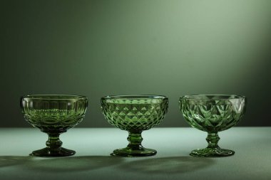 Yeşil arka planda izole edilmiş üç dondurma yeşil bardak.