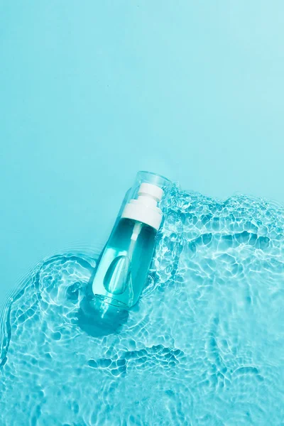 Blå Kosmetisk Flaska Vitt Fyrkantigt Podium Och Den Blå Vattenytan — Stockfoto