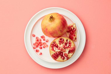 Pastel pembe arka planda gri tepside nar. Asgari düzeyde. Üst Manzara. Boşluğu kopyala