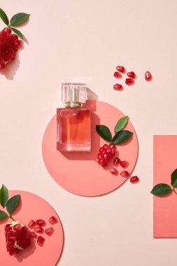 Nar özlü kozmetik ürünleri için boş arkaplan. Tam nar ve nar tohumları podyum çemberinde renk arka planında. Üst Manzara. Düz görünüm.