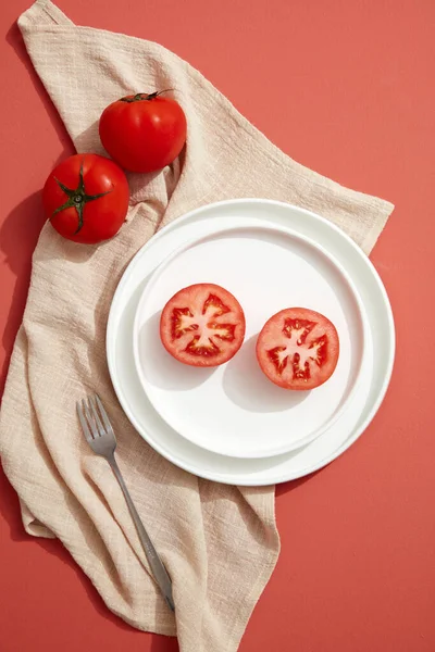 用亚麻布餐巾把西红柿铺在瓷盘上的最低限度的平铺 平躺在地上 俯瞰四周 — 图库照片
