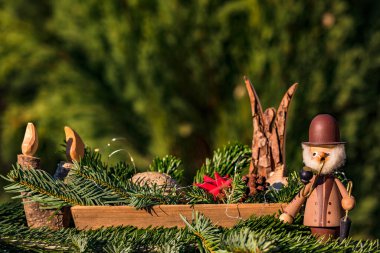 Dekoratif elementlerle dolu bir kase sigara, melek ve Noel için ahşap mum gibi.