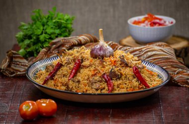 Lezzetli Fergana pilavı. Özbek 'in tahta zemin üzerindeki en sevdiği yemek