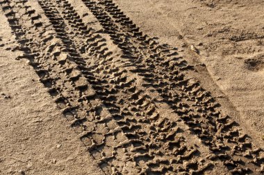 Kirli kum yolda araba parçaları.