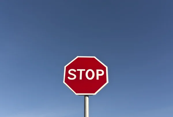 Röd stoppskylt och blå himmel. — Stockfoto