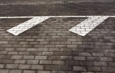 Kaldırım üzerinde beyaz trafik işaretleri.