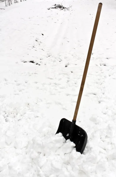 Black shovel in snow. — Stock Photo, Image