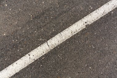 Gri asfalt yüzeyi beyaz çizgi.