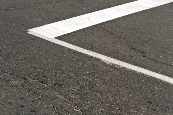 Mark van de witte verf op de oude asfaltweg. — Stockfoto