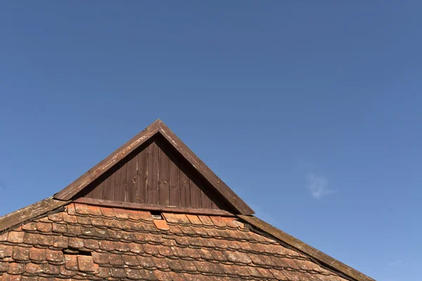 Altes Ziegeldach gegen blauen Himmel. — Stockfoto