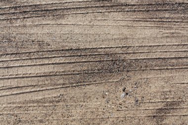 Kumlu yolda araba parçaları. 