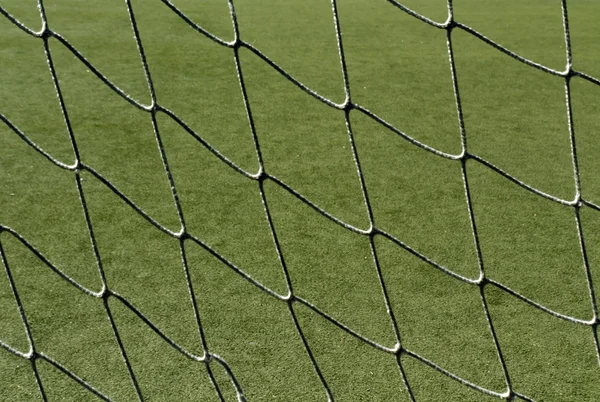 Fußballnetz und grünes Feld. — Stockfoto