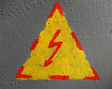Pis yüzeyde elle boyanmış elektrik tehlikesi işareti var. İşaretler ve semboller arka plan                        