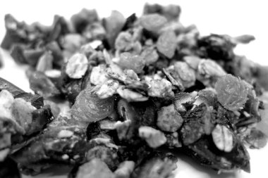 Siyah ve beyaz olarak bulanık efektli beyaz üzerine lezzetli granola. Gıda ve malzeme arka planı.