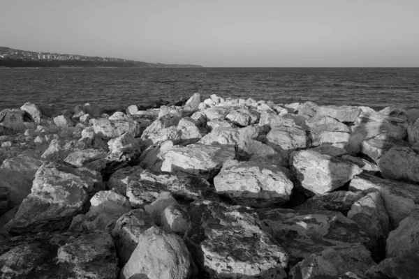 黒と白の海で防波堤として使用される石 海の景色と背景 — ストック写真