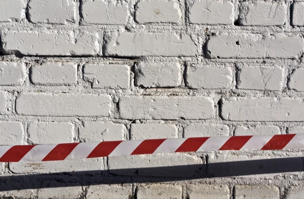 Roter und weißer Streifen vor Ziegelmauer. — Stockfoto