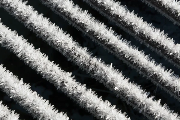 Neve e geada na superfície da grade de metal. close-up — Fotografia de Stock