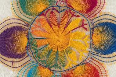 Bej kumaş üzerine tek bir renkli Nanduti dantel çemberinin makro ayrıntıları. Otantik Paraguay örümcek ağı dantel dizaynı. Parlak renkli iplikler..