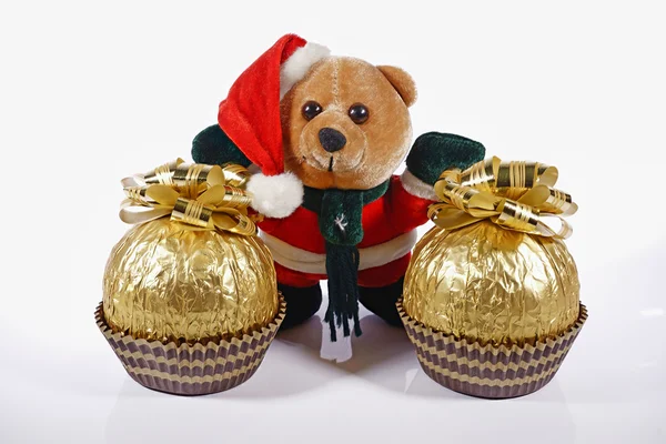 Ayı beyaz bir arka plan üzerinde hediyeler ile Noel Baba gibi giyinmiş.