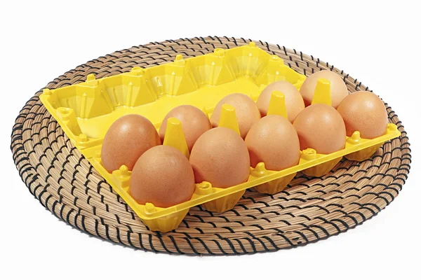 Hühnereier in Schachtel gelbe Farbe auf weißem Hintergrund und Docht — Stockfoto