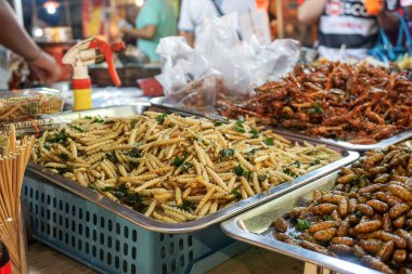 Exotic food, one of the extreme Asian tourisme attraction. Night market in Bangkok, Thailand. clipart