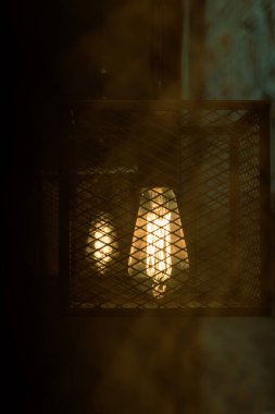 Kafesteki tungsten ışığının sessiz renginde yakın çekim.