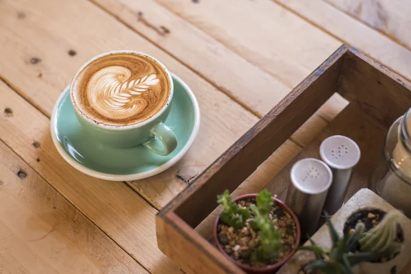Καυτό καπουτσίνο με latte τέχνη σε φόντο ξύλου — Φωτογραφία Αρχείου