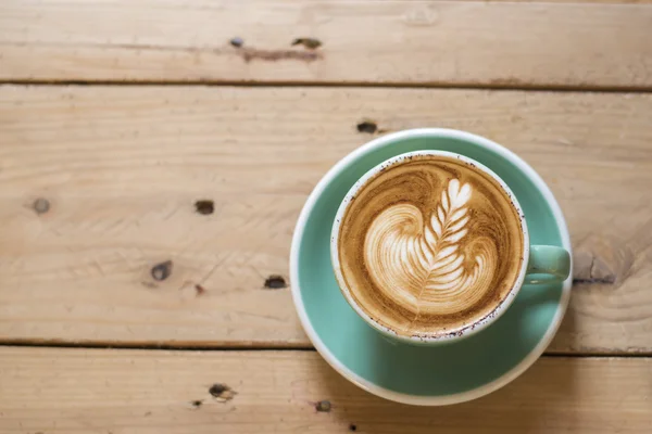 Cappuccino quente com arte latte sobre fundo de madeira — Fotografia de Stock