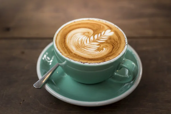 Καυτό καπουτσίνο με latte τέχνη σε φόντο ξύλου — Φωτογραφία Αρχείου