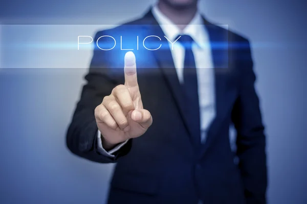 Рука бізнесмена торкається кнопки POLICY на віртуальному екрані — стокове фото