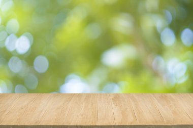 Yeşil yaprakları bokeh arka plan bulanıklık ile ahşap zemin 