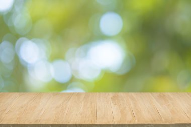 Yeşil yaprakları bokeh arka plan bulanıklık ile ahşap zemin 