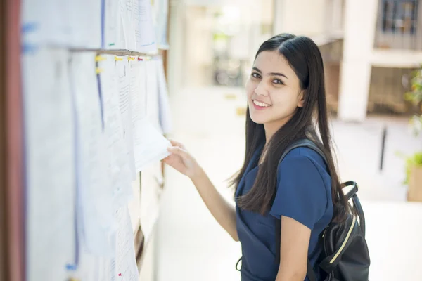 Een vrouwelijke universiteitsstudent is spannend met het verslag-examen — Stockfoto