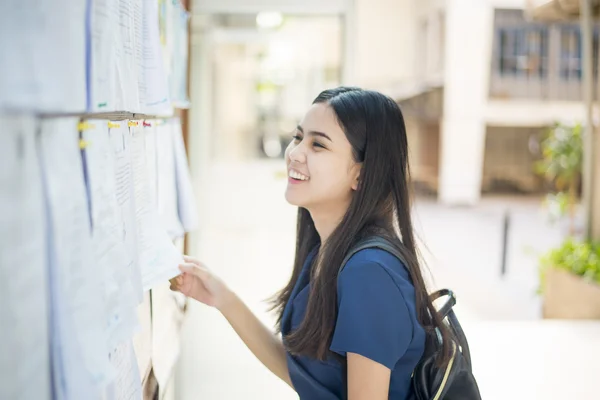 Een vrouwelijke universiteitsstudent is spannend met het verslag-examen — Stockfoto