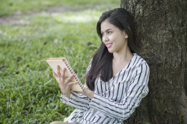 Çekici kadın parkta bir kitap okuma 