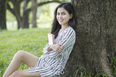 Çekici kadın parkta bir kitap okuma 