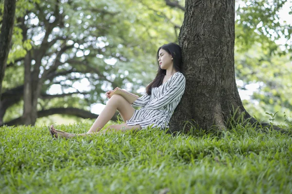 Çekici kadın parkta bir kitap okuma 