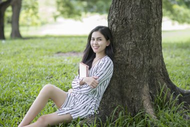 Çekici kadın parkta bir kitap okuma 