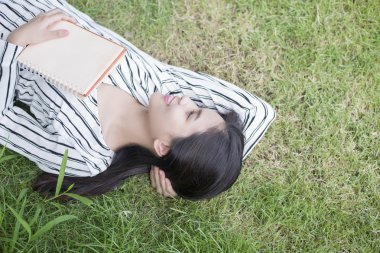 Çekici kadın parkta bir kitap okuma 