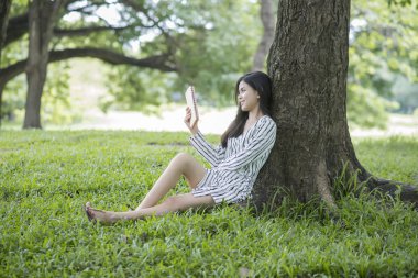 Çekici kadın parkta bir kitap okuma 