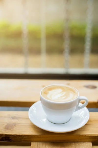 Ζεστό latte art στο παρασκήνιο τραπέζι από ξύλο — Φωτογραφία Αρχείου