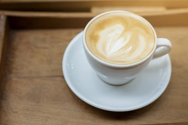 Ahşap masa arka plan üzerinde sıcak latte sanat — Stok fotoğraf